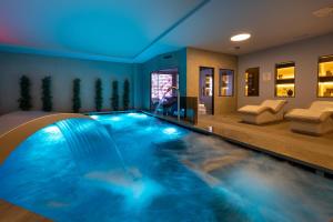 a swimming pool in a house with a blue ceiling at Grand Plaza Hotel & Wellness in Andorra la Vella