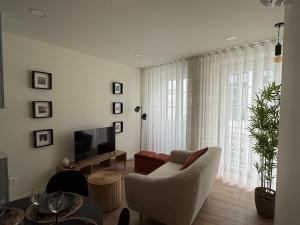 a living room with a couch and a television at La Maison de Ré in Vila Real