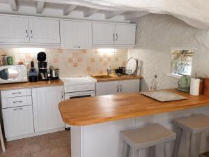 a kitchen with white cabinets and a wooden counter top at Le pigeonnier in Le Verdier