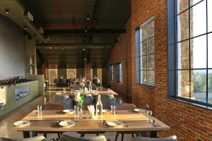 a restaurant with wooden tables and chairs and a brick wall at Northern Residency in Srinagar