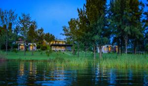 a house on the shore of a body of water at Eben Lake Kivu cottages and Villas in Kagano