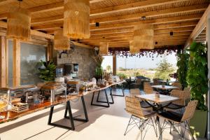 a restaurant with tables and chairs and a bar at Aegean Hospitality in Mikonos