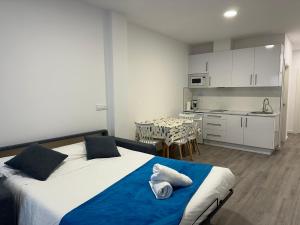 a bedroom with a bed and a kitchen with a table at GRUPOELE3 MUXIA PUERTO in Muxia