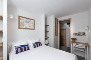 a bedroom with a white bed and a table at Maison entière à 100m de la mer in Antibes
