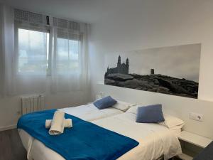 a bedroom with two beds with towels on them at GRUPOELE3 MUXIA PUERTO in Muxia