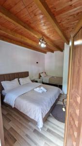 a bedroom with a large bed with a wooden ceiling at Guest House in Theth Agostini in Theth +14 photos