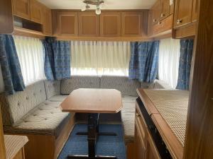a small room with a wooden table in a caravan at Stumpf Verpachtung Gbr in Treuchtlingen