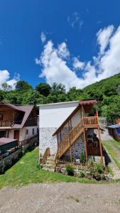 a house with a wooden deck on the side of it at Guest House in Theth Agostini in Theth