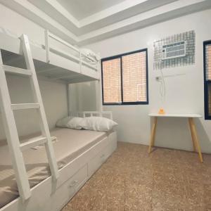 a bedroom with a bunk bed and a ladder at Duck & Drift - a Sleeper Hostel - Just 1,7km from Airport in Puerto Princesa City
