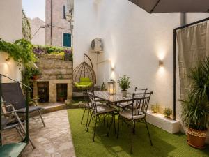 a patio with a table and chairs and a fireplace at Quiet Oasis in the Heart of Old Town- two kitchen,3bath in Split