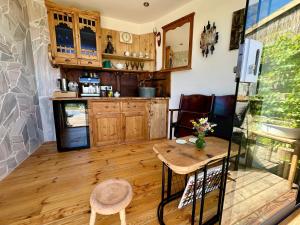 a kitchen with wooden floors and a table and chairs at Mauthnerhube Ferienwohnung mit Sauna, Whirlpool, Hüttenfeeling in Sankt Oswald ob Eibiswald