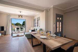 a dining room and living room with a table at K for Kefalonia in Karavomylos