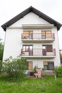 a white building with balconies and a yard at Apartment Bojke in Niš