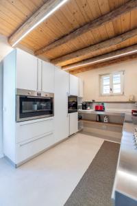 a kitchen with white cabinets and a wooden ceiling at Agriturismo Monte Bisson - Piscina Privata in Soave