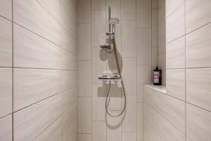a shower with a glass shower head in a bathroom at Chambres D'hôtes Les Carmes in La Flocellière