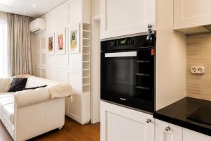 a kitchen with a black oven and a couch at Top 10 3BR2BH Jacuzzi Free Parking in Sofia