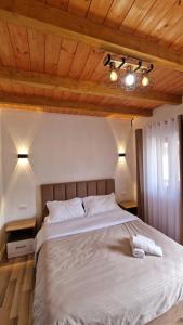 a bedroom with a large white bed with wooden ceilings at Guest House in Theth Agostini in Theth