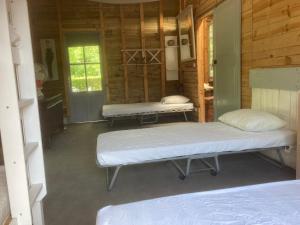 a room with two beds in a log cabin at Dortoir en charente in Jarnac