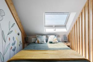 a small bedroom with a bed with a window at chambre d'hôtes des bleuets in Saint-Firmin-des-Prés