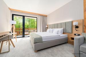 a bedroom with a bed and a desk and a chair at Platinum Mountain Hotel&SPA in Szklarska Poręba +42 photos