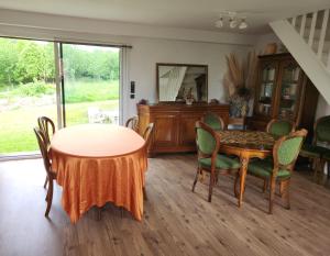 a dining room with a table and chairs and a mirror at Chambres d'hôtes pleine nature in Plougonven +20 photos