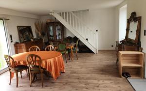 a dining room with a table and chairs and a staircase at Chambres d'hôtes pleine nature in Plougonven
