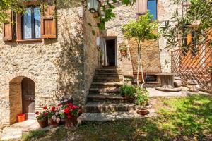 a stone house with stairs leading up to a door at Appartamento Brunello Murlo in Murlo