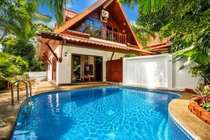 a swimming pool in front of a house at Tropical Family Retreat near Ya Nui Beach - Villa Nikkie in Nai Harn Beach