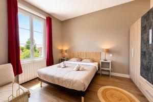 a bedroom with two beds and a window at L'Esprit Descartes in Roanne
