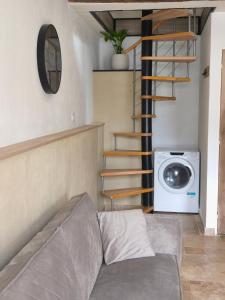 a living room with a couch and a washing machine at La Maisonnette Montlouisienne in Montlouis-sur-Loire