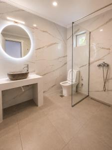 a bathroom with a sink and a toilet and a mirror at Panagiotis' Seaside Apartment, Giorgos`House in Gialova