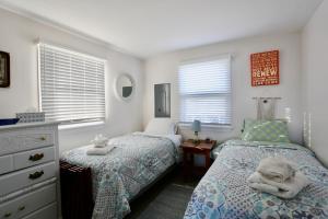 a bedroom with two beds and a dresser at Pet-Friendly Private Beach Oceanfront Cottage in Charlestown