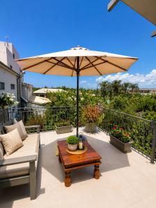 a patio with a table and an umbrella at Panagiotis' Seaside Apartment, Giorgos`House in Gialova