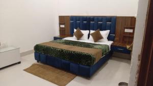 a bedroom with a bed with a blue headboard at Swayambhu Hotel in Rudraprayāg