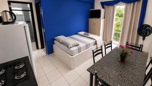 a small room with a bed and a table and chairs at Pousada das Águas in Piratuba