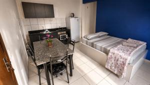 a small kitchen with a table and a bed at Pousada das Águas in Piratuba