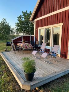 a deck with chairs and a table on a house at Brygghuset between Hjo and Tidaholm in Hjo