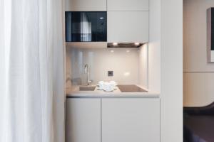 a bathroom with a sink and a microwave at Hotel White Lisboa in Lisbon