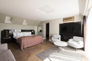 a bedroom with a bed and two chairs and a tv at Hotel Skt. Annæ in Copenhagen +69 photos