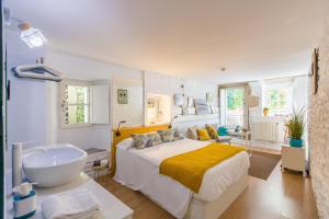 a bedroom with a bed and a tub and a sink at roomPEDRA apartamentos turísticos in Santiago de Compostela
