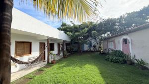 a backyard of a house with a grass yard at Vila Maré Alta Caraiva in Caraíva