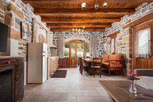 a kitchen and dining room with a stone wall at Manelis Mills Estate, Guest Houses & Restaurant in Plakias +38 photos