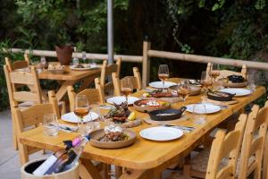 a wooden table with glasses of wine and food on it at Manelis Mills Estate, Guest Houses & Restaurant in Plakias