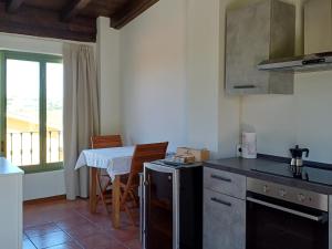 a kitchen with a stove and a table with chairs at Calice dei Cherubini in Montecalvo Versiggia