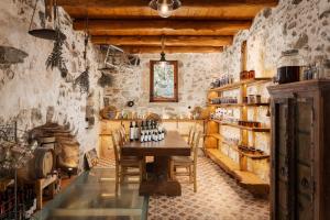 a tasting room with a table and a fireplace at Manelis Mills Estate, Guest Houses & Restaurant in Plakias