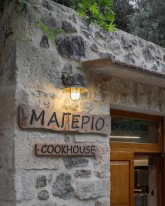 a sign on the side of a stone building at Manelis Mills Estate, Guest Houses & Restaurant in Plakias