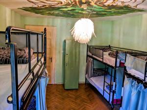a room with two bunk beds and a chandelier at The Re-Born Hostel in Timişoara