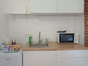 a kitchen counter with a sink and a microwave at Calice dei Cherubini in Montecalvo Versiggia