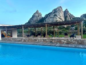 a resort with a swimming pool with mountains in the background at A Santa Trinita in Bonifacio