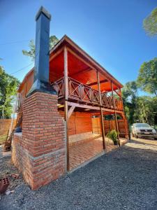 a brick house with a fireplace in front of it at Encantos del Monte in Gobernador Roca